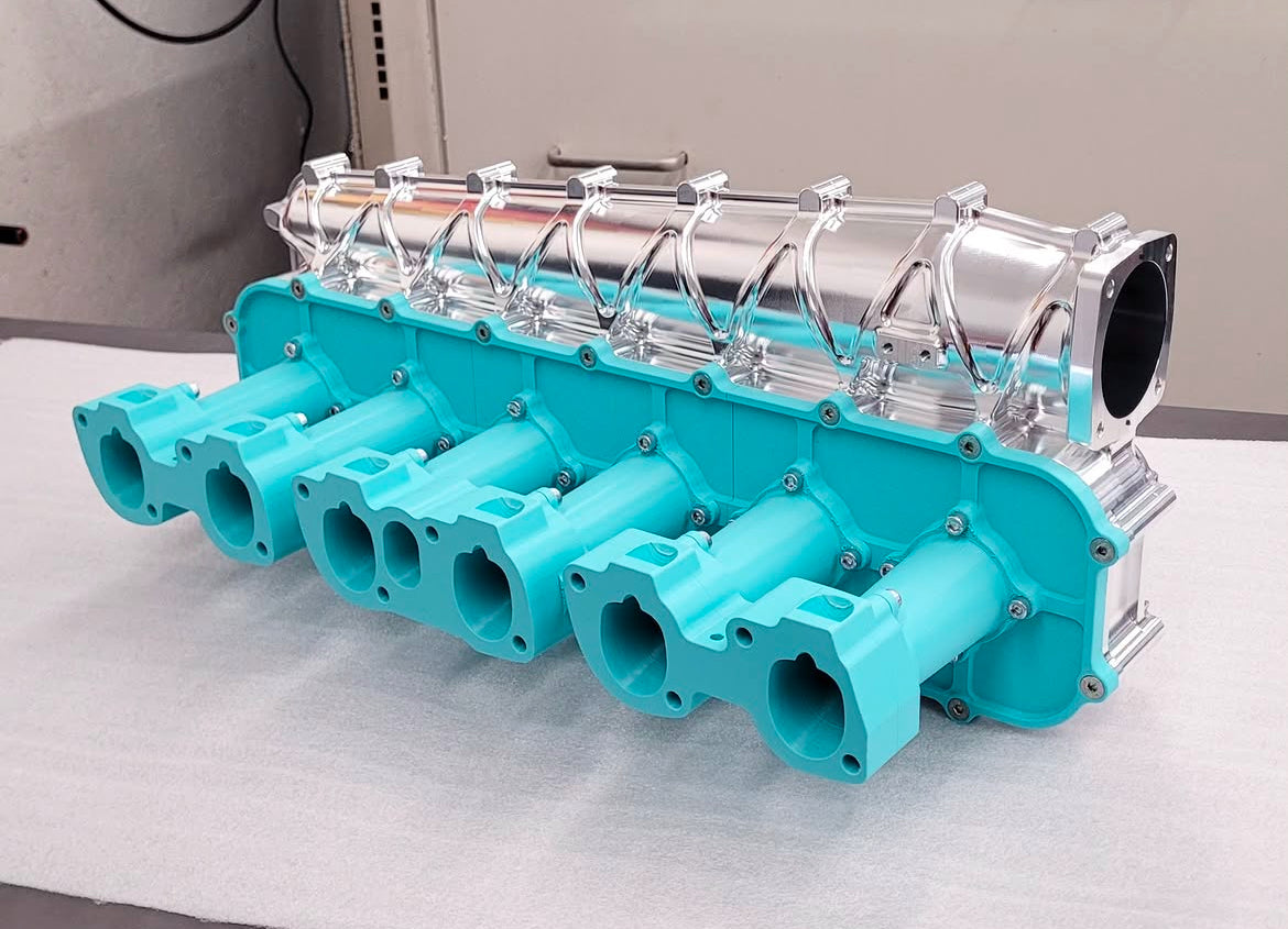Intake manifold prototype beside the finished billet assembly